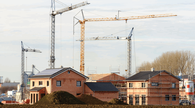 Baustellenkräne mit Krangabeln Mehrere Baustellen von Wohnhäusern mit Baustellenkränen